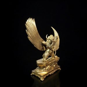 a gold statue of a winged man