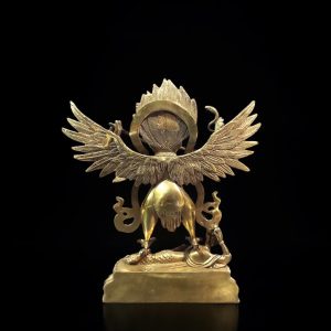 a gold statue of a winged creature