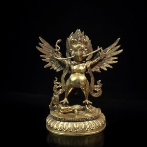 a gold statue of a dragon with wings and a snake