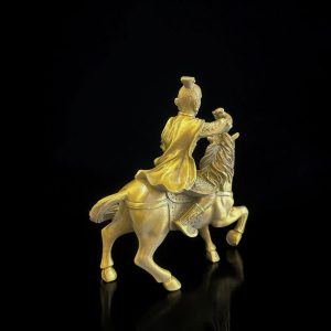 a gold statue of a man riding a horse